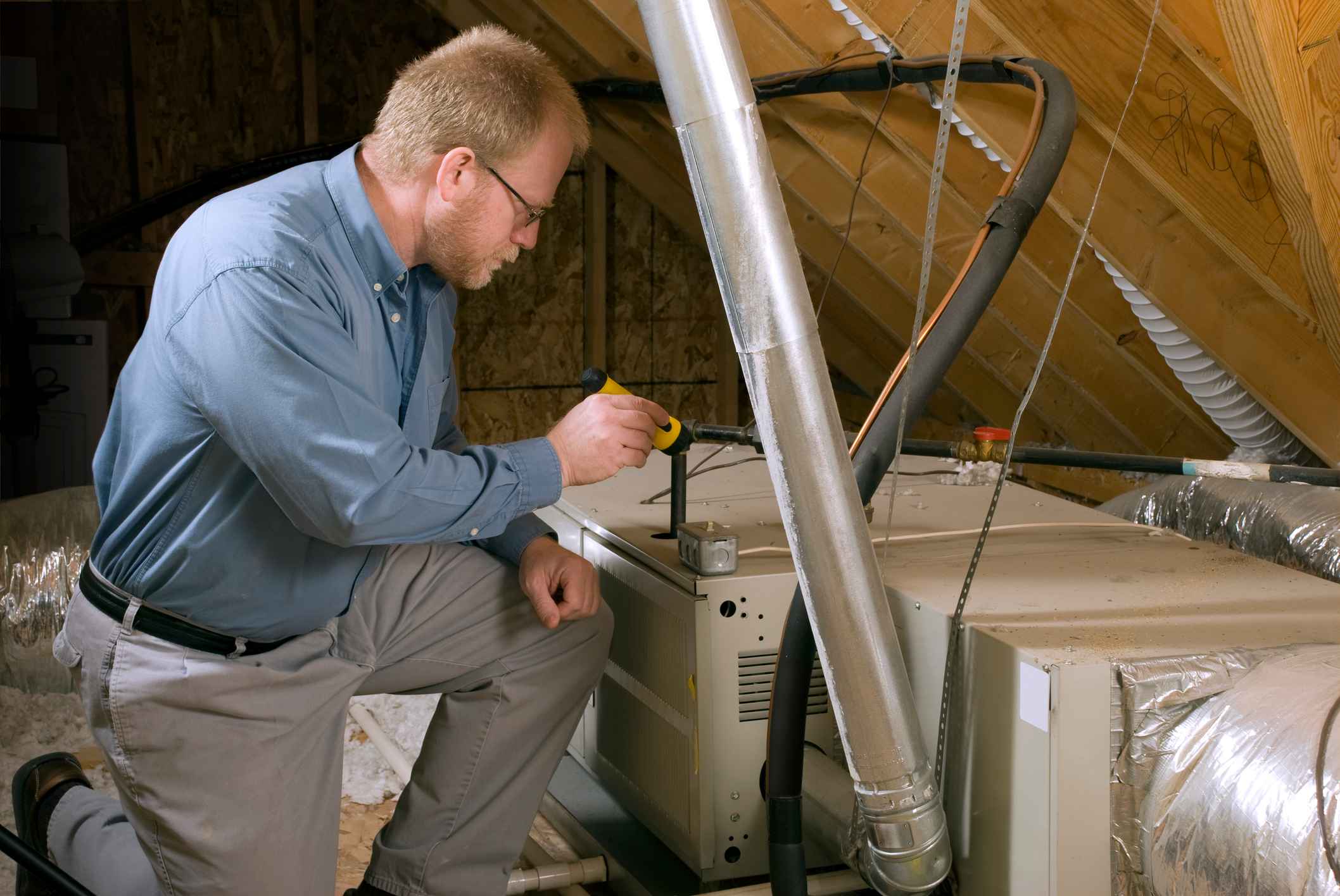 Service Man Inspects Furnace