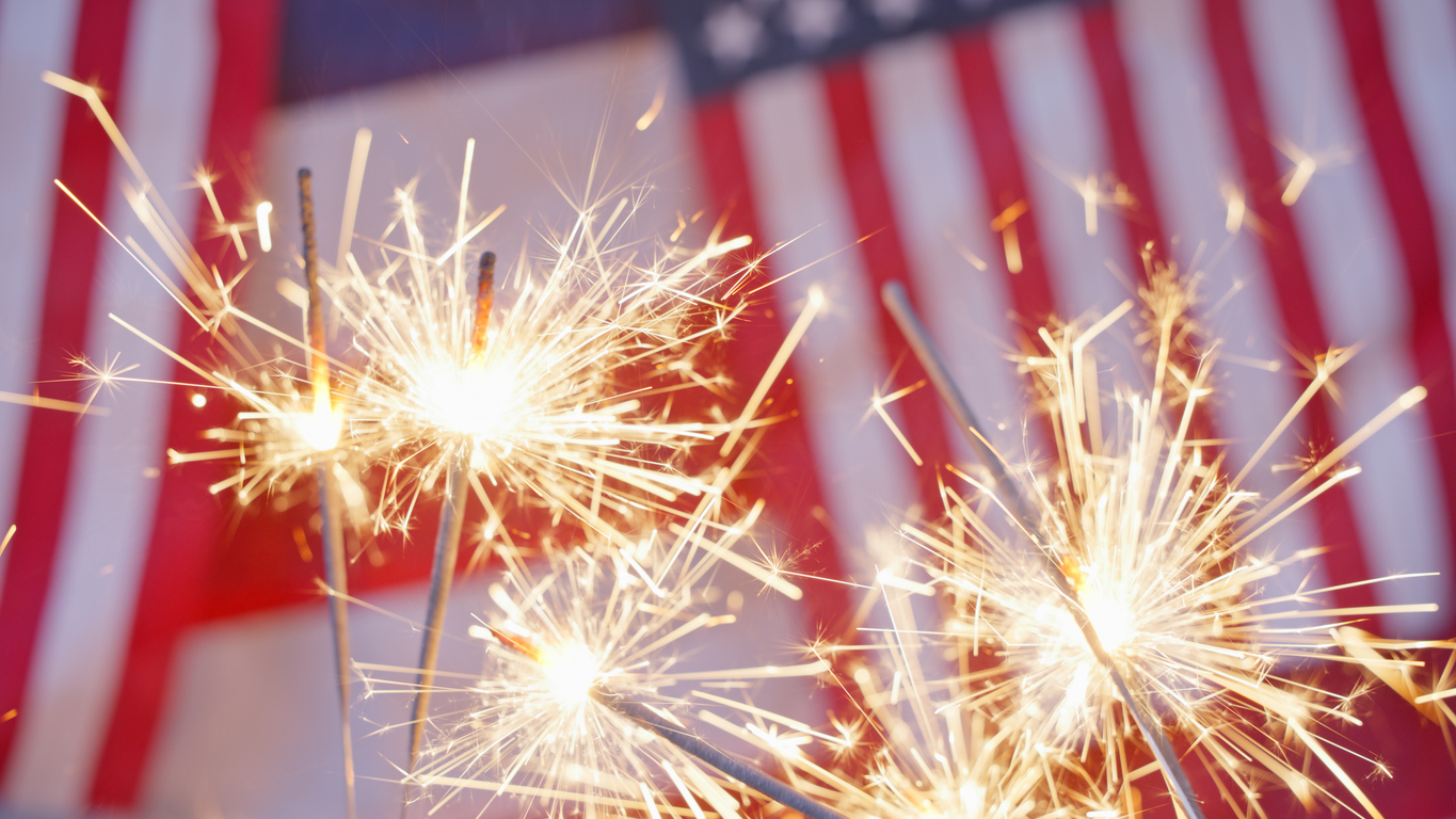 Sparklers with an American flag background.