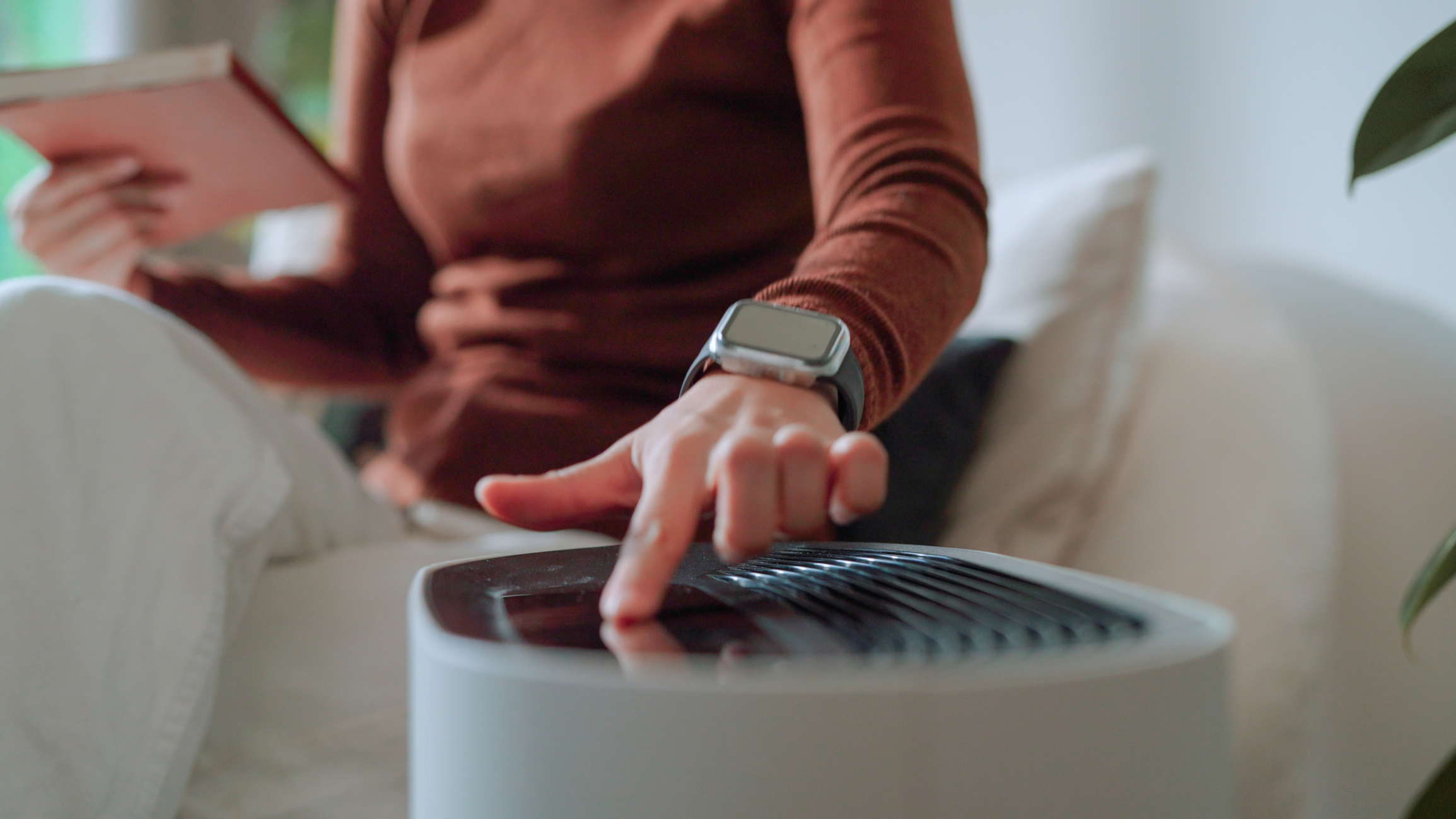 Asian woman working at home while vacuum cleaner and air purifier are working