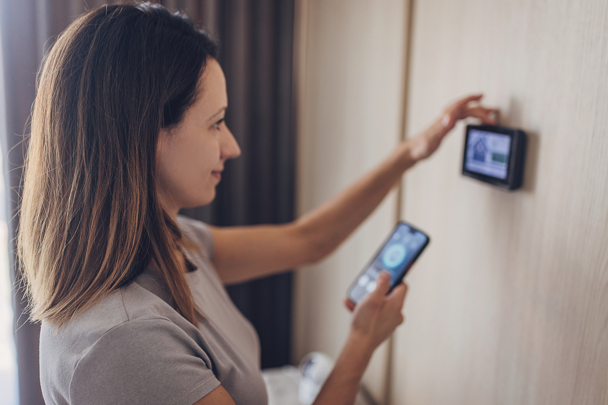 Woman Controlling Smart Thermostat