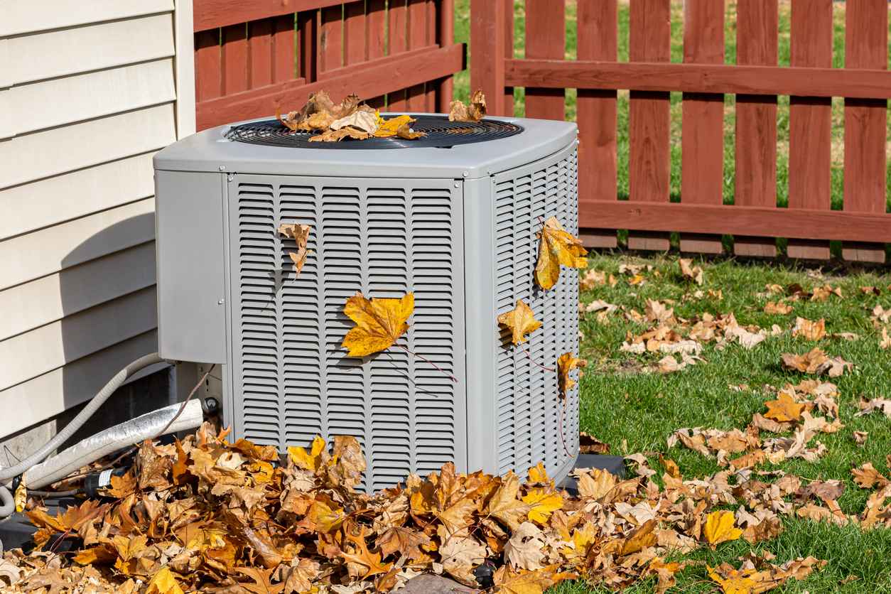 Outdoor HVAC system with leaves surrounding it due to the fall weather