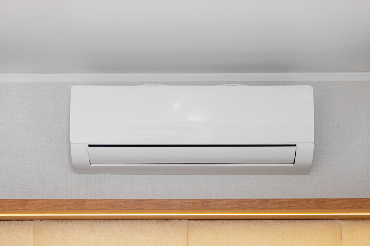 Ductless air conditioner mounted on wall in room