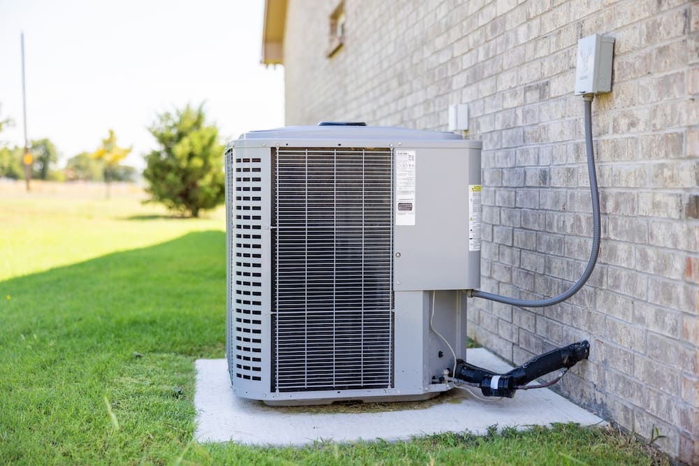 Modern outdoor HVAC unit on concrete slab outside of a residential home
