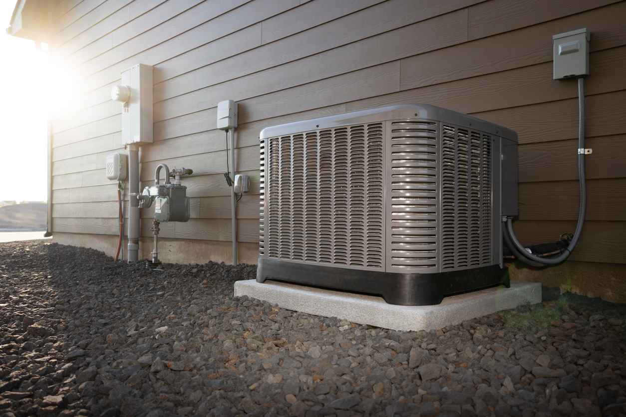 Outdoor air conditioning system on a concrete slab outside of a house