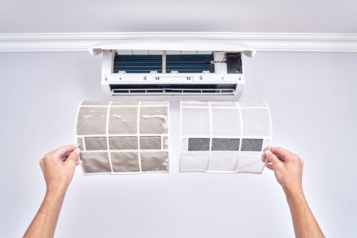 Homeowner replacing the air filter in a ductless mini split unit. Image shows a side by side comparison of the clean and dirty filters.