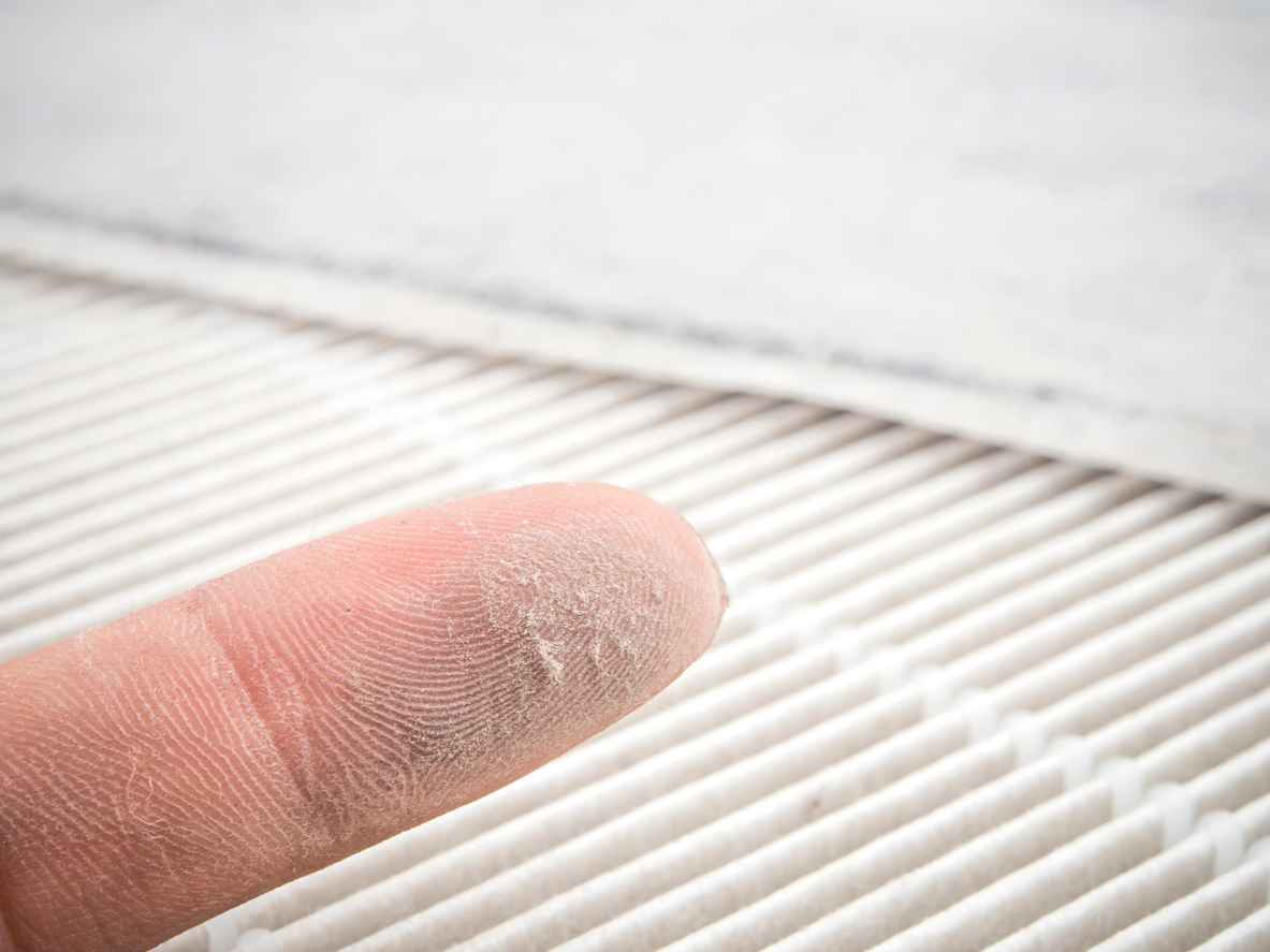 Finger with dust on it after wiping the dust off of the AC filter